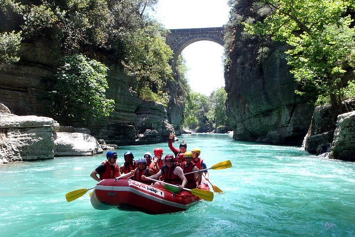 Family-friendly Alanya rafting group on calm turquoise river section inside the canyon