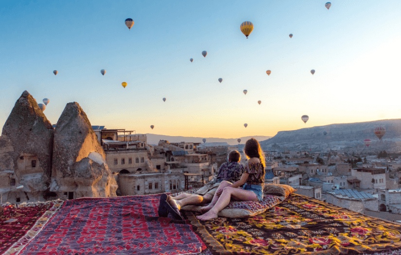 Couple relaxing on rooftop carpet in Cappadocia
